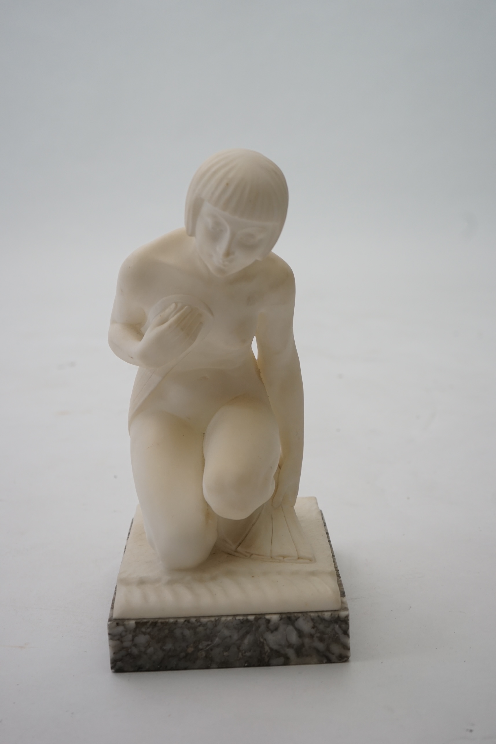 Manner of Gugliemo Pugi (1850-1915). An Italian Art Deco carved marble figure of a crouching bather kneeling and semi-draped